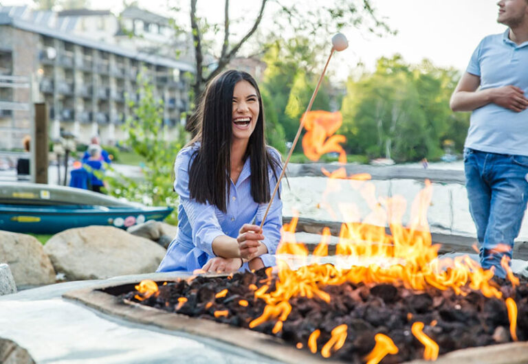 Golde Arrow Resort fire pit with laughing woman roasting a marshmellow 768x530